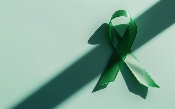Eine grüne Schleife, symbolisch für Leberkrebs. | © AdobeStock_769331660