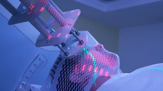 Ein Mann liegt auf einer Liege und erhält eine Strahlentherapie im Gesicht.  | © AdobeStock-272740505