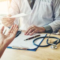 Ein Arzt überreicht ein Dokument | © AdobeStock-170129174