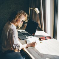 Eine junge Frau am Schreibtisch | © AdobeStock-455241962