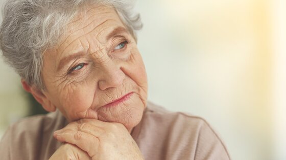 Eine ältere Frau schaut nachdenklich | © AdobeStock-138899879